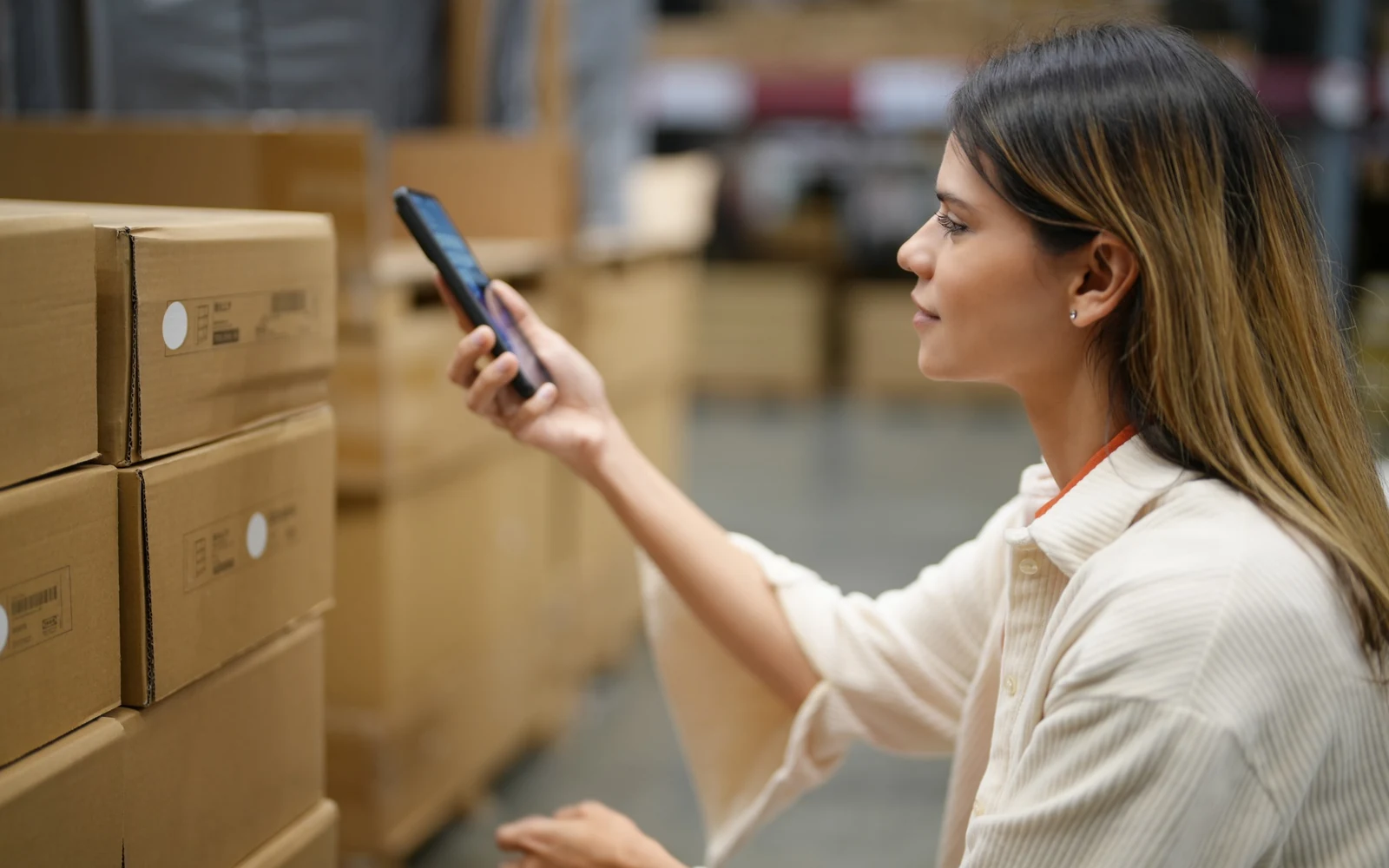 Warehouse worker using mobile technology representing an asset intelligence transformation